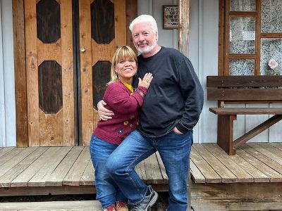 Amy Roloff and Chris Marek are holding each other as they are posing for the picture.